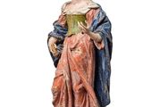 an old statue of a woman holding a book on top of a table