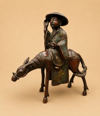 bronze statue of a man riding a horse with a hat on his head