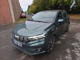 La voiture verte est garée sur le bord de la route.