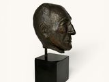 an image of a bronze head of a man on a black stand
