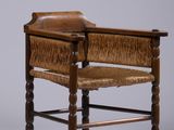 une vieille chaise en bois avec une assise en cuir et des pieds en bois