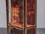 an antique display cabinet with a glass door and gold trimmings