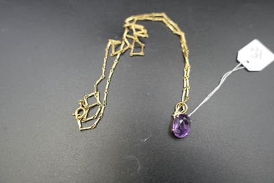 un gros plan d'un collier avec une pierre violette sur un fond noir