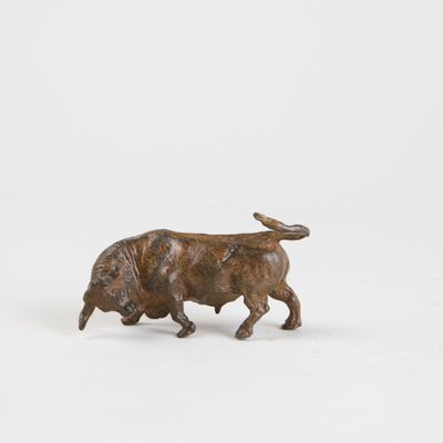 figurine représentant un taureau sur une surface blanche, avec un fond blanc