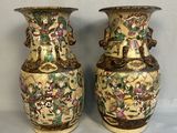 une paire de vases chinois anciens posés sur une table, sur fond gris