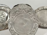 three silver plated dishes on a white surface with a white background