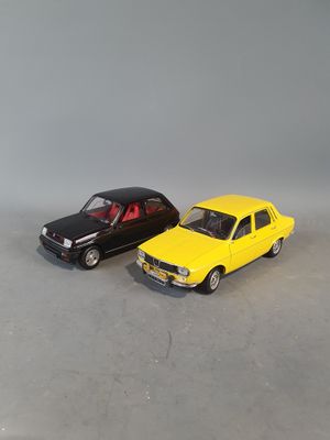 two toy cars are sitting side by side on a gray surface
