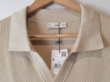 the sweater is hanging on a hanger on the wall