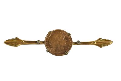 a close up of a coin on a gold arrow pin