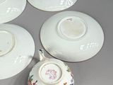 six porcelain cups and saucers sitting on top of a table
