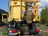 a yellow dump truck that is parked on the side of the road