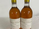 two bottles of wine sitting on a table next to each other