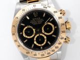 a black and gold watch on a white surface