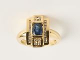 gros plan d'une bague en or avec un saphir et des diamants