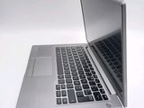 a silver laptop computer sitting on top of a white table