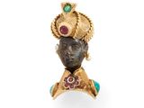 un gros plan d'une bague en or ornée d'une tête en pierre