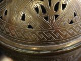 a close up of a metal vase with a design on it
