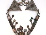 a close up of a necklace on a white surface