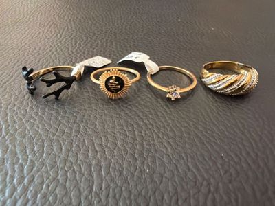 a group of five rings sitting on top of a leather surface