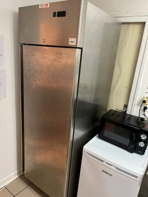 un réfrigérateur argenté et un micro-ondes dans une petite cuisine