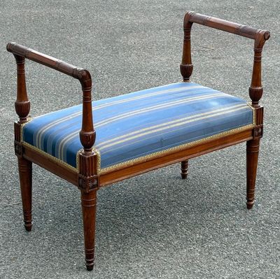 un banc sur lequel est posé un coussin rayé bleu et blanc