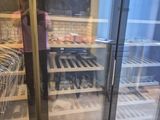 une femme debout devant un réfrigérateur à vin