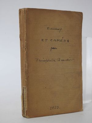 an old book sitting on top of a table next to a glass