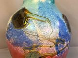 a vase with a colorful design on it sitting on a table