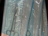 three pairs of scissors are wrapped in plastic bags on a table