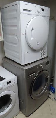 deux lave-linge et un sèche-linge empilés les uns sur les autres