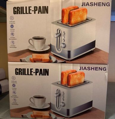 deux boîtes de grille-pain posées sur une table, à côté d'une tasse de café