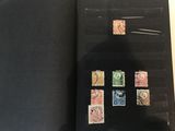 un livre ouvert avec des timbres, posé sur une table