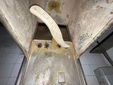 a dirty metal door with a banana sticking out of it