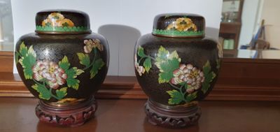 two vases sitting on a table with a mirror in the background