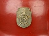 a red fire hydrant with a gold emblem on it