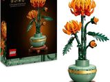 un vase vert contenant des fleurs orange, posé à côté d'une boîte noire