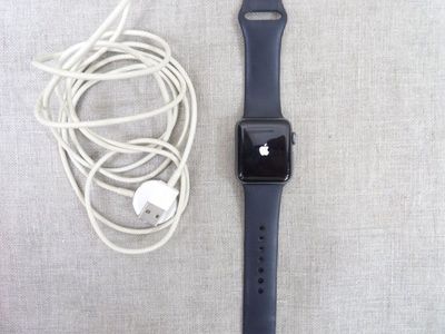 une Apple Watch et des écouteurs posés à côté d'un chargeur