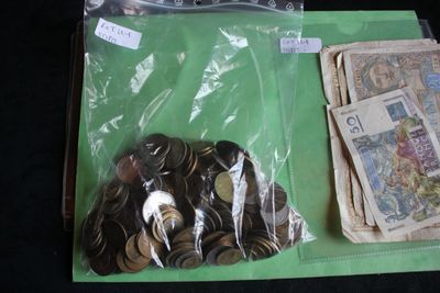 a pile of coins and a bag of money on a table