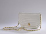 a white purse with a gold chain hanging from it