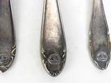 three spoons and a fork are sitting on a white surface