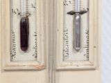 two thermometers that are on the side of a door