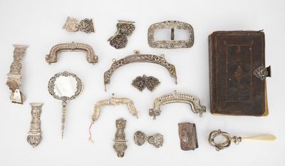 an assortment of silver objects including a book, knife, and other items