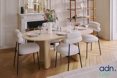 une salle à manger avec une table, des chaises et une bibliothèque