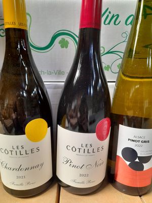trois bouteilles de vin posées sur une table à côté d'une boîte de vin