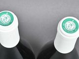 two bottles of wine sitting next to each other on a table