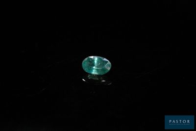 a close up of a green emerald stone on a black surface