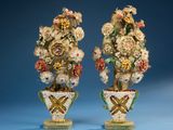 pair of porcelain vases with flowers in them against a blue background