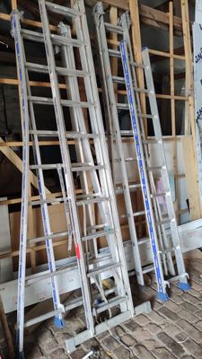 many ladders that are stacked up in a room
