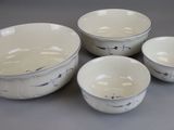three bowls and two cups are sitting on a table