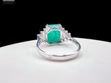an image of a ring with a green stone